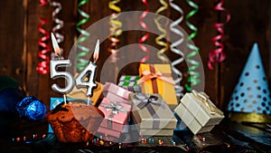 Birthday background with muffin and candles with number 54. Beautiful anniversary background with cake copy space with burning