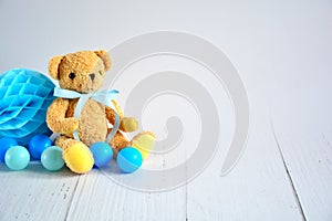 Birthday boy background with teddy bear , blue small balls and honeycomb ball , party decoration , space for text