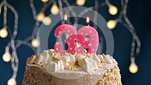 Birthday cake with 39 number burning by lighter pink candle on blue backgraund. Candles are set on fire. Slow motion