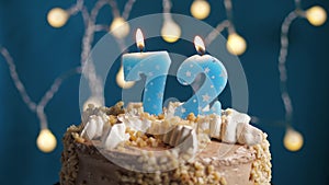 Birthday cake with 72 number candle on blue backgraund