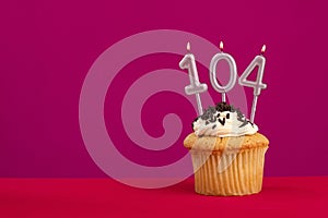 Birthday cake with candle number 104 - Rhodamine Red foamy background