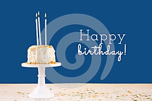 Birthday cake with candles on classic blue with Happy birthday wording. Birthday party celebration concept