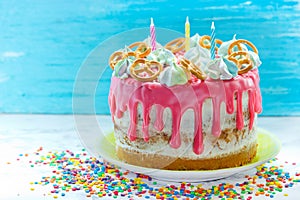 Birthday cake decorated with pink icing, meringue, sprinkle and