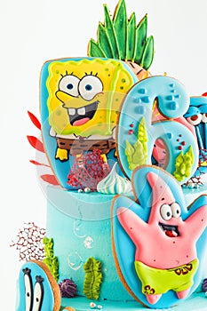 Birthday cake for a fan of SpongeBob SquarePants on white background. Nautical turquoise bunk cake with characters of animated