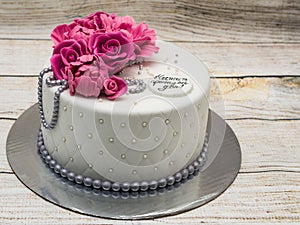 Birthday cake with fondant flowers - roses and peonies and silver pearls. Inscription `Happy Birthday`