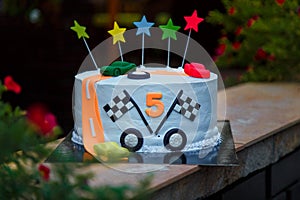 Birthday cake with mastic stars and cars figures for boy 5 years old anniversary