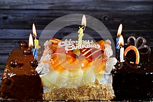 Birthday cake of three different pieces spongy creamy cake for celebrations, hazelnut chocolate spread, dark chocolate, caramel,