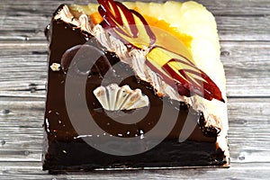 Birthday cake of two halves different pieces spongy creamy cake for celebrations, dark chocolate, caramel, whipped vanilla cream,