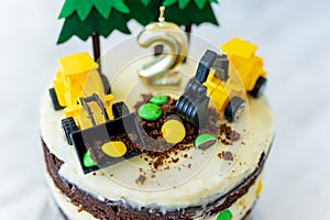 Birthday cake for two year old boy, decorated with felt trees and construction vehicles. Car themed homemade cake for birthday