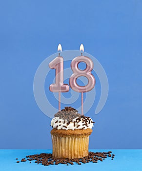 Birthday candle with cupcake on blue background - Number 18