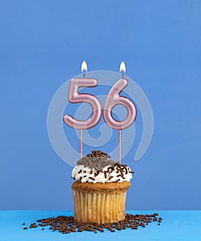 Birthday candle with cupcake on blue background - Number 56