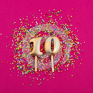 Birthday candle number 10 - Anniversary celebration in rhodamine red background