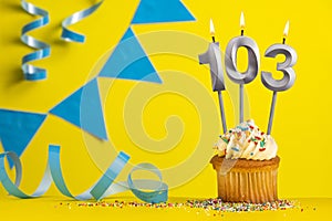 Birthday candle number 103 with cupcake - Yellow background with blue pennants