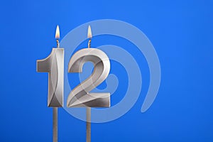 Birthday candle number 12 - Celebration card on blue background