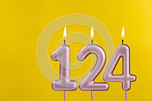 Birthday candle number 124 - Birthday celebration on yellow background