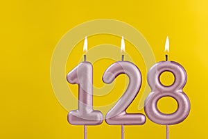 Birthday candle number 128 - Birthday celebration on yellow background