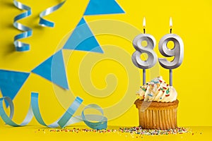 Birthday candle number 89 with cupcake - Yellow background with blue pennants