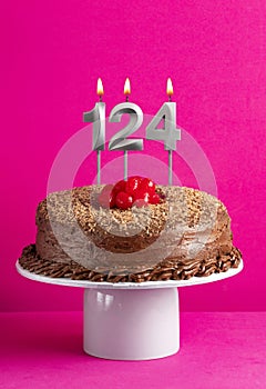Birthday card with candle number 124 - Chocolate cake on pink background