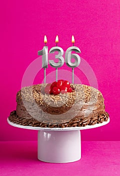 Birthday card with candle number 136 - Chocolate cake on pink background
