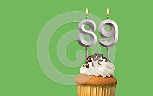 Birthday card with candle number 89 - Cupcake on green background