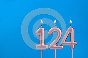 Birthday card with number 124 - Burning anniversary candle on blue background