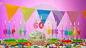 Birthday card with number 60 year. Happy birthday to a six ten year old. Candles burn with a festive cream cake. Greeting card