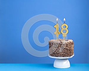 Birthday celebration with candle 18 - Chocolate cake on blue background