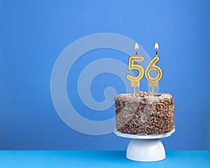Birthday celebration with candle 56 - Chocolate cake on blue background