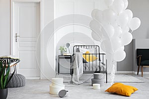 Birthday celebration in white industrial bedroom with metal bed and concrete floor