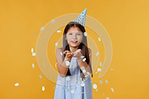 birthday child girl blowing confetti off her hands