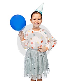 happy girl in birthday party hat blowing balloon