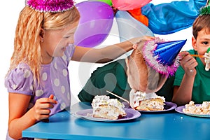 Birthday children celebrate party and eating cake on plate together .