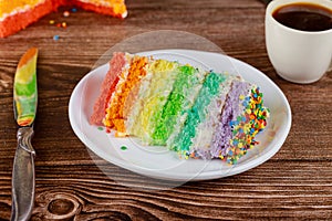 Birthday colorful rainbow cake with cup of coffee and knife
