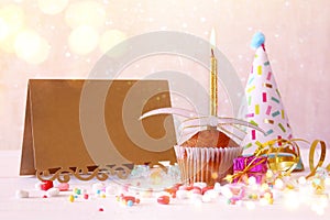 Birthday concept with cupcake next to empty greeting card