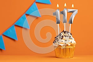 Birthday cupcake with candle number 117 - Orange background