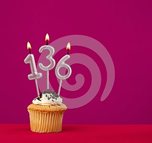 Birthday cupcake with candle number 136 - Rhodamine Red foamy background