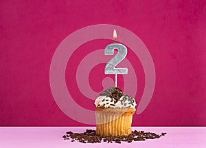 Birthday cupcake with candle number 2 - Birthday card on pink background