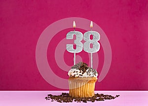 Birthday cupcake with candle number 38 - Birthday card on pink background