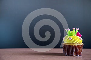 Birthday cupcake in front of a black background Cupcake with yellow cream