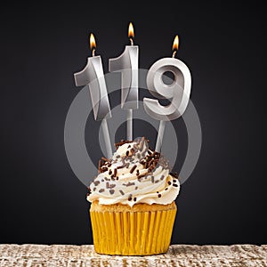 birthday cupcake with number 119 candle - Celebration on dark background