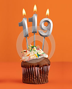 Birthday cupcake with number 119 candle - Orange color background