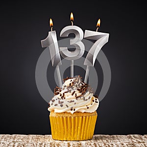 birthday cupcake with number 137 candle - Celebration on dark background