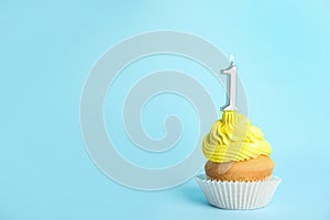 Birthday cupcake with number one candle on blue background