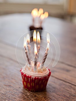 Birthday cupcakes with lots of lit candles
