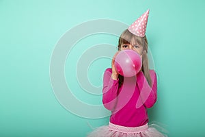 Birthday girl blowing a balloon