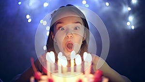 Birthday of the little girl she blows out candles on cake. Slow motion