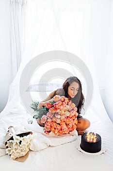 Birthday morning of young woman with huge bouquet of roses and tasty cake
