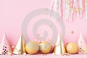 Birthday or party background with carnival cap, golden balloons and confetti. Festive greeting card