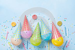 Birthday or party background. Funny balloons, candy and confetti on blue table top view. Flat lay. Invitation card.