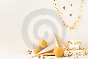 Birthday or party background with golden balloons, gift box, carnival cap and confetti